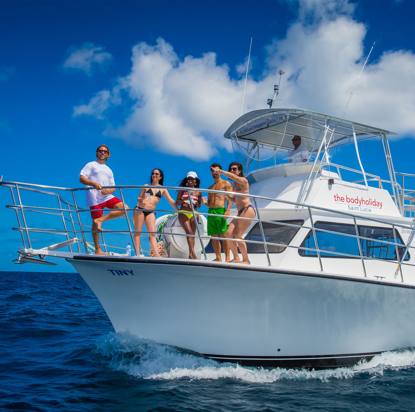 a WHITE Motor Vessel with a few people on board ploughing thru the waves